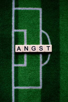 Das Coronavirus (Covid-19) verursacht Veranstaltungsabsagen von beispielsweise Fußballspielen der Bundesligaprofiligen auf unbestimmte Zeit und viele Auswirkungen, im Bild: Das Wort Angst auf einem Fußballteppich. Deutschland