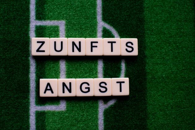 Das Coronavirus (Covid-19) verursacht Veranstaltungsabsagen von beispielsweise Fußballspielen der Bundesligaprofiligen auf unbestimmte Zeit und viele Auswirkungen, im Bild: Das Wort Zukunftsangst auf einem Fußballteppich. Deutschland