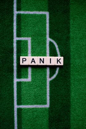 Das Coronavirus (Covid-19) verursacht Veranstaltungsabsagen von beispielsweise Fußballspielen der Bundesligaprofiligen auf unbestimmte Zeit und viele Auswirkungen, im Bild: Das Wort Panik auf einem Fußballteppich. Deutschland