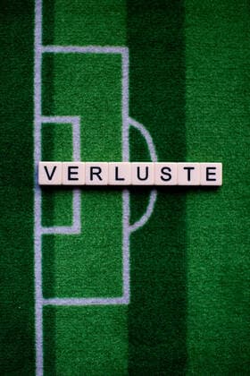 Das Coronavirus (Covid-19) verursacht Veranstaltungsabsagen von beispielsweise Fußballspielen der Bundesligaprofiligen auf unbestimmte Zeit und viele Auswirkungen, im Bild: Das Wort Verluste auf einem Fußballteppich. Deutschland