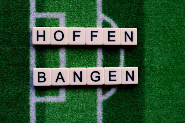 Das Coronavirus (Covid-19) verursacht Veranstaltungsabsagen von beispielsweise Fußballspielen der Bundesligaprofiligen auf unbestimmte Zeit und viele Auswirkungen, im Bild: Das Wort Hoffen und Bangen auf einem Fußballteppich. Deutschland