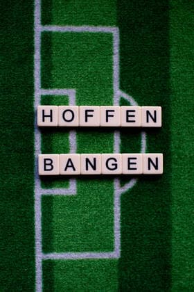 Das Coronavirus (Covid-19) verursacht Veranstaltungsabsagen von beispielsweise Fußballspielen der Bundesligaprofiligen auf unbestimmte Zeit und viele Auswirkungen, im Bild: Das Wort Hoffen und Bangen auf einem Fußballteppich. Deutschland