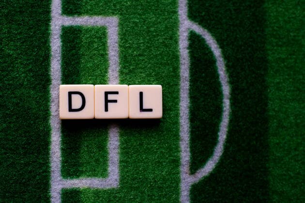 Das Coronavirus (Covid-19) verursacht Veranstaltungsabsagen von beispielsweise Fußballspielen der Bundesligaprofiligen auf unbestimmte Zeit und viele Auswirkungen, im Bild: Das Wort DFL auf einem Fußballteppich. Die Deutsche Fußballliga steht vor Entscheidungen, wie der Spielbetrieb fortgesetzt wird. Deutschland
