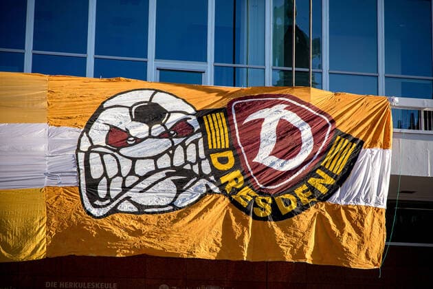 Montag Morgen - In Sachsen gilt aufgrund des neuartigen Coronavirus eine Ausgangsbeschränkungen, so auch in Dresden. Im Bild: Böser Ball (Logo der Ultras Dynamo) und Dynamo-Logo als Teil des Spruchbands der ULTRAS DYNAMO am Kulturpalast: DRESDEN HAT ES OFT GEZEIGT, IN DER NOT HILFT NUR ZUSAMMENHALT. AUCH DIESE KRISE WERDEN WIR ÜBERSTEHEN. DANKE AN ALLE, DIE TÄGLICH ALLES DAFÜR GEBEN. 30.03.2020, Dresden Altstadt, Deutschland, Dresden