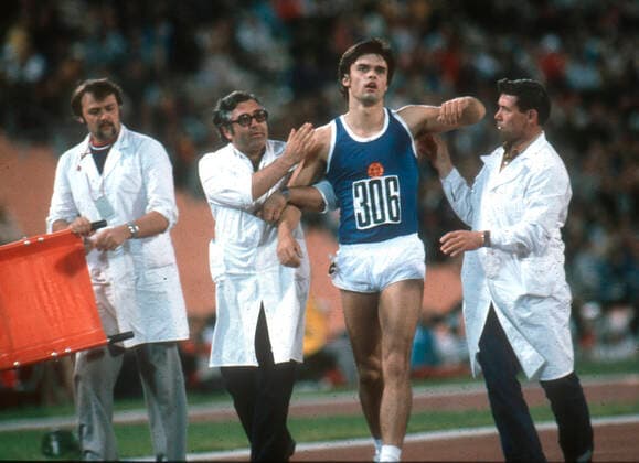 Olympiade 1980 Moskau Leichtathletik Steffen Grummt (DDR) erschöpft nach den abschließenden 1500 Metern des Zehnkampfes, wird von Sanitätern gestützt 26.07.1980 *** Olympics 1980 Moscow Athletics Steffen Grummt GDR exhausted after the final 1500 meters of decathlon, is supported by paramedics 26 07 1980 HM
