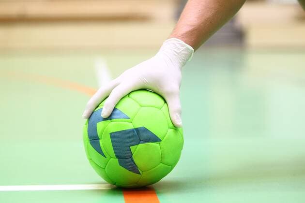 Hygiene in Zeiten des Coronavirus: Eine Hand in Einweghandschuhen an einem Handball Handball in der Coronakrise Handball in der Coronakrise Limburg Copyright: xWeissx Eibner-Pressefotox EP_rws