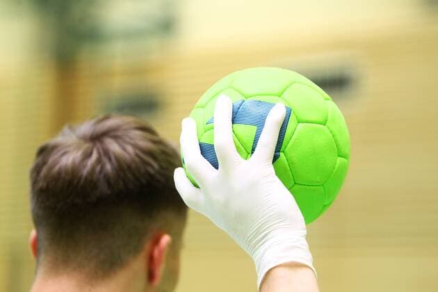 Hygiene in Zeiten des Coronavirus: Eine Hand in Einweghandschuhen an einem Handball Handball in der Coronakrise Handball in der Coronakrise Limburg Copyright: xWeissx Eibner-Pressefotox EP_rws