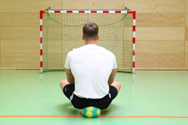 Wann kann nach der Coronapause wieder Handball gespielt werden? Ein Mann sitzt wartend auf einem Handball vor einem leeren Handballtor Handball in der Coronakrise Handball in der Coronakrise Limburg Copyright: xWeissx Eibner-Pressefotox EP_rws