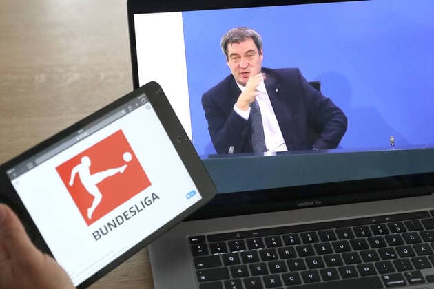 Symbolfoto am 02.05.2020 Auf einem Laptop läuft die Pressekonferenz von Bundeskanzlerin Angela Merkel im Anschluss an das Gespräch mit den Regierungschefinnen und -chefs der Länder im Zusammenhang mit dem Coronavirus - aus dem Kanzleramt. Logo der DFL. Markus Söder Soeder. Vertagt die Entscheidung wann und ob die Bundesliga wieder losgehen kann.
