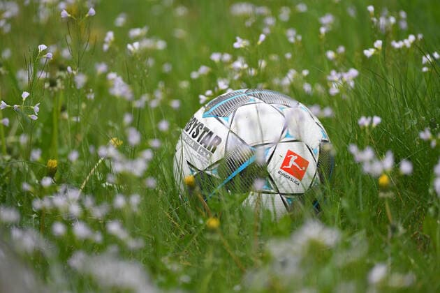 DFL meldet insgesamt zehn positive Corona Tests in der 1.und 2. Bundesliga Archivfoto: Randmotiv,Feature-offizieller Spielball Derbystar liegt einer nicht gemaehten Wiese in hohem Gras und Wiesenblumen. FC Bayern Muenchen Training in der Coronavirus Pandemie in Kleingruppen. Training an der Saebener Strasse. Fussball 1. Bundesliga,Saison 2019 2020, am 02.05.2020 Â