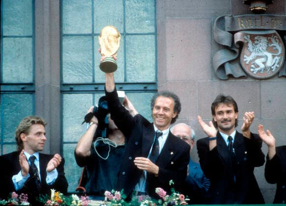 Empfang der Weltmeister 1990 auf dem Frankfurter Römerberg 09.07.1990. Bundestrainer Franz Beckenbauer mit dem WM - Pokal, links Thomas Häßler , rechts TW Raimond Aumann *** Reception of the 1990 World Champions at Frankfurts Römerberg 09 07 1990 National Coach Franz Beckenbauer with the World Cup, left Thomas Häßler , right TW Raimond Aumann HM