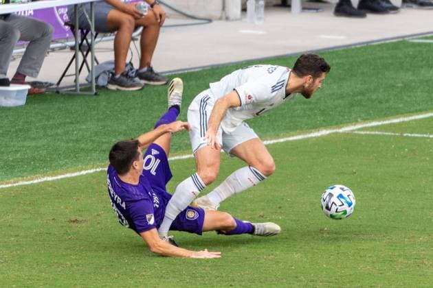 ORLANDO, USA, NOV 28TH Forward Teal Bunbury ( 10 New England) fall to the ground whle battling for the ball in the Major League Soccer Playoff match between Orlando City and New England at Exploria Stadium in Orlando *NO COMMERCIAL USAGE Stacy White SPP Orlando City v New England 