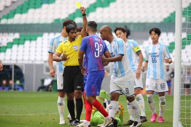 DOHA, QATAR - NOVEMBER 30: Match referee Khamis Al Marri books Joan Oumari of FC Tokyo after he fouls Su-huk Jo of Ulsan Hyundai during the AFC Champions League Group F match between FC Tokyo and Ulsan Hyundai at the Education City Stadium on November 30, 2020 in Doha, Qatar. (Photo by Colin McPhedran) SPO, SOC, FOC  Copyright: xColinxMcPhedran