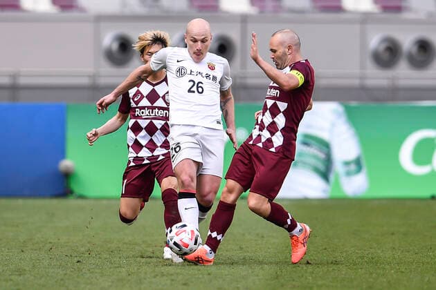 Australian professional football player Aaron Mooy of Shanghai SIPG F.C., middle, protects the ball during the group match of 20 21 AFC Champions League (ACL) against Vissel Kobe, Doha city, Qatar, 7 December 2020. Vissel Kobe defeated Shanghai SIPG F.C. with 2-0.
