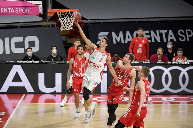 27.12.2020, xemx, Basketball BBL Bundesliga, FC Bayern Muenchen Basketball - Brose Bamberg emspor, v.l. Dominico Lockhart (Brose Bamberg) mit Korbleger Paul Zipser (FC Bayern Basketball) und Leon Radosevic (FC Bayern Basketball) schauen zu Muenchen