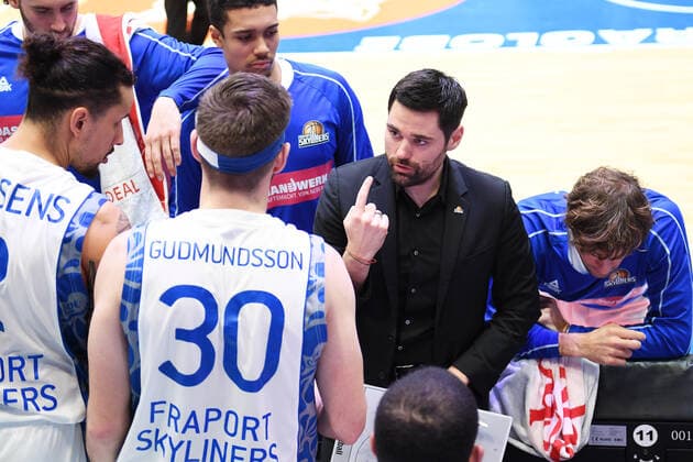Basketball 1. Bundesliga, Saison 2020 2021, 11. Spieltag, Syntainics MBC Weißenfels vs. Fraport Skyliners Frankfurt Main (01.01.2021) Sebastian Gleim (Headcoach Fraport Skyliners Frankfurt) (2.v.r.) mit einer Ansage im Spielerkreis bei einer Auszeit beim Spiel MBC Weißenfels gegen Fraport Skyliners (02.01.2021). Zudem zu sehen u.a. Michael Kessens (Fraport Skyliners Frankfurt, Rueckennummer 2) und Jon Gudmundsson (Fraport Skyliners Frankfurt, Rueckennummer 30). Weißenfels Sachsen-Anhalt Deutschland Stadthalle Weißenfels