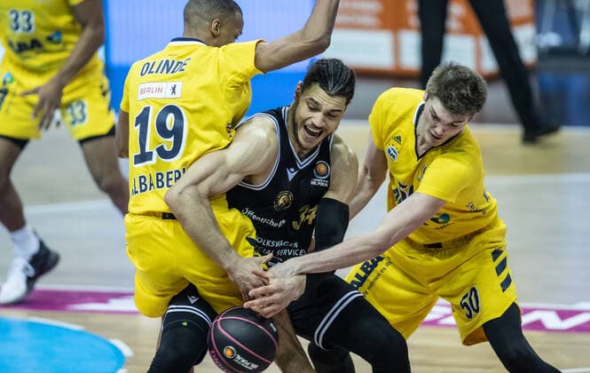 20.01.2021, Berlin, Basketball, MagentaSport BBL Pokal, Vorrunde, 1.Spieltag, Mercedes Benz Arena: ALBA Berlin - Basketball Loewen Braunschweig. Gavin Schilling (M) von Loewen Braunschweig kaempft gegen ALBAs Louis Olinde (l) und Ben Lammers um den Ball. ALBA Berlin - Loewen Braunschweig