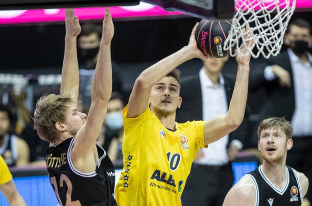 20.01.2021, Berlin, Basketball, MagentaSport BBL Pokal, Vorrunde, 1.Spieltag, Mercedes Benz Arena: ALBA Berlin - Basketball Loewen Braunschweig. ALBAs Tim Schneider (r) springt zum Korb gegen Jannik Goettsche von Loewen Braunschweig. ALBA Berlin - Loewen Braunschweig