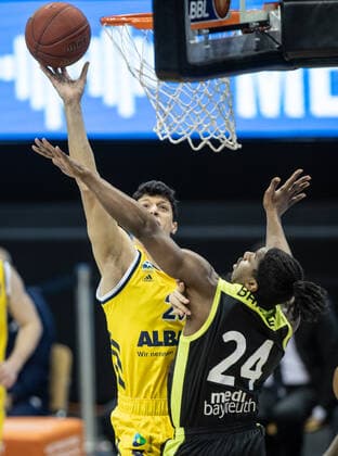 12.02.21, Berlin, Basketball, 1. Bundesliga, easyCredit BBL, Hauptrunde, 18.Spieltag, Mercedes Benz Arena: ALBA Berlin - medi Bayreuth. ALBAs Simone Fontecchio (l) springt zum Korb gegen Frank Bartley von medi Bayreuth. ALBA Berlin - medi Bayreuth