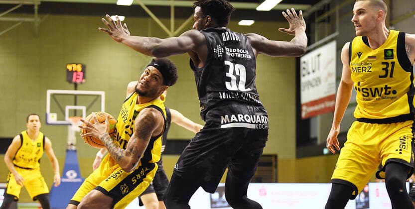 Basketball 2. Bundesliga 2020 2021 13. Spieltag in Rottenburg in der Volksbank Arena 27.02.2021 Tigers Tuebingen - Science City Jena Troy Simons (li, Tigers) gegen Norense Owen Odiase (Mitte, Jena) und beobachtet von Daniel Keppeler (re, Tigers)
