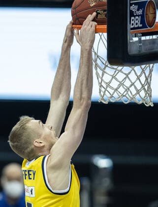 28.02.21, Berlin, Basketball, 1. Bundesliga, easyCredit BBL, Hauptrunde, 21.Spieltag, Mercedes Benz Arena: ALBA Berlin - HAKRO Merlins Crailsheim. ALBAs Niels Giffey legt den Ball in den Korb und haengt daran. ALBA Berlin - HAKRO Merlins Crailsheim
