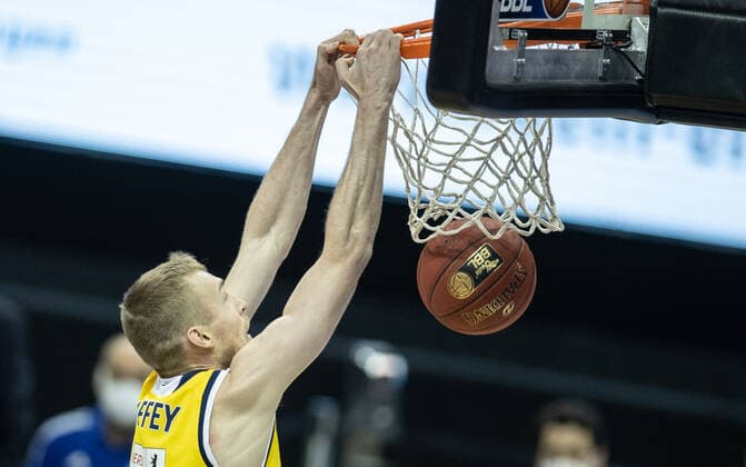 Sport Bilder des Tages 28.02.21, Berlin, Basketball, 1. Bundesliga, easyCredit BBL, Hauptrunde, 21.Spieltag, Mercedes Benz Arena: ALBA Berlin - HAKRO Merlins Crailsheim. ALBAs Niels Giffey legt den Ball in den Korb und haengt daran. ALBA Berlin - HAKRO Merlins Crailsheim