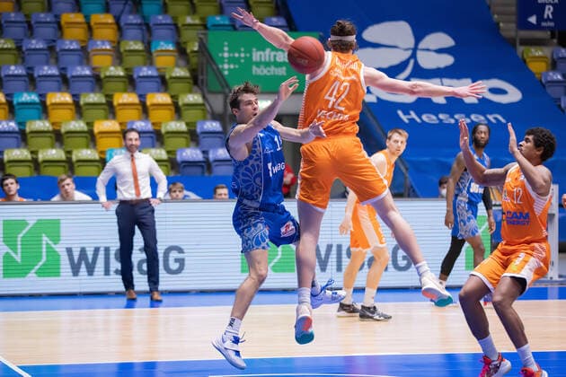 Fraport Skyliners - RASTA Vechta, easyCredit BBL Joe Rahon (Fraport Skyliners, 18) gegen Dennis Clifford (RASTA Vechta, 42). Rechts Edgar Sosa (RASTA Vechta, 12). Basketball-Spiel der easyCredit BBL zwischen den Fraport Skyliners und RASTA Vechta am 4. Maerz 2021 in der Fraport-Arena in Frankfurt am Main., Frankfurt am Main Hessen Deutschland Fraport-Arena