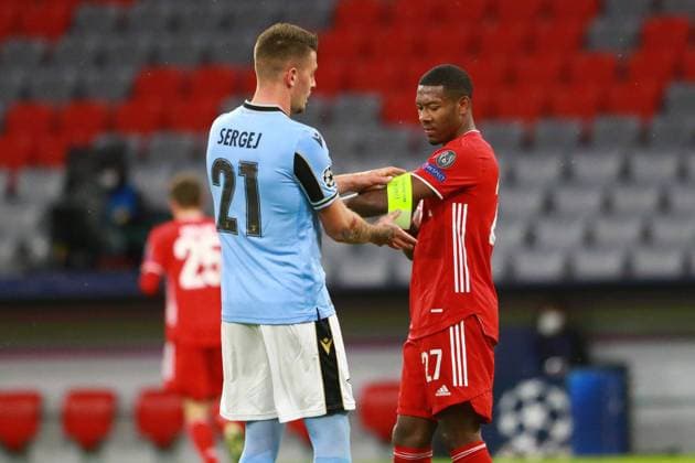 Kurios: 21 Sergej MilinkoviÄ‡-SaviÄ‡ (Lazio Rom) hilft 27 David Alaba mit der Kapitänsbinde Fussball, Champions League, FC Bayern München - Lazio Rom, 17.03.2021 FOTO: Mladen Lackovic LakoPress