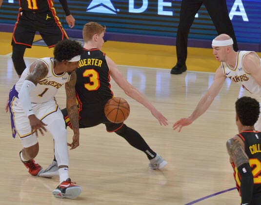 Los Angeles Lakers guard Alex Caruso and Atlanta Hawks guard Kevin Huerter chase the loose ball during the first half at Staples Center in Los Angeles on Saturday, March 20, 2021. Le Bron James asked to be taken out of the game after suffering a right ankle injury. Without James, the Lakers lost to the Hawks 99-94.  LAP2021032013