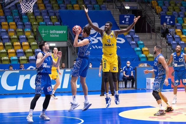 Fraport Skyliners - Alba Berlin, easyCredit BBL Michael Kessens (Fraport Skyliners, 2) holt sich den Rebound gegen Christ Koumadje (Alba Berlin, 21). Links schaut Bruno Vrcic (Fraport Skyliners, 7) zu, rechts Rasheed Moore (Fraport Skyliners, 20) und Quantez Robertson (Fraport Skyliners, 23). Basketball-Spiel der easyCredit BBL zwischen den Fraport Skyliners und Alba Berlin am 21. Maerz 2021 in der Fraport-Arena in Frankfurt am Main., Frankfurt am Main Hessen Deutschland Fraport-Arena