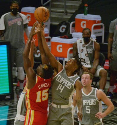 Los Angeles Clippers guard Terance Mann battles Atlanta Hawks center Clint Capela for the offensive rebound during the fourth quarter at Staples Center in Los Angeles on Monday, March 22, 2021. The Clippers defeated the Hawks 119-110 with the comeback victory.  LAP2021032207 JIMxRUYMEN