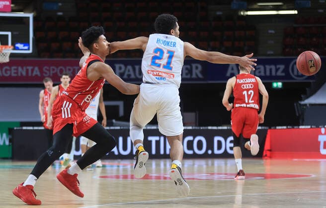 23.03.2021, BBL, FC Bayern Basketball vs Mitteldeutscher BC, Audi Dome, Muenchen, im Bild: Jason George (FCB Basketball) bekommt auf der Nase von Quinton Hooker (Mitteldeutscher BC)