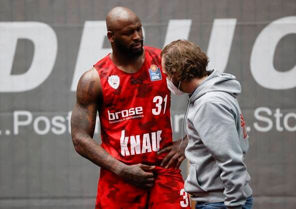 28.03.2021, Basketball, BBL 2020 2021, 25. Spieltag, s.Oliver Wuerzburg - Telekom Baskets Bonn, GER, Wuerzburg, s.Oliver Arena, Bild: v. li. Murphy Holloway (s.Oliver Wuerzburg) zeigt Dr. Kai Fehske eine Verletzung an der Leiste an Copyright: HMBxMedia xHeikoxBecker