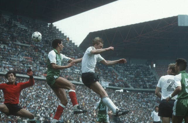 Fussball-Weltmeisterschaft 1982 in Spanien. Vorrunde: Algerien - Deutschland 2:1 16.06.1982 in Gijon. Kopfballszene im Strafraum der Algerier. Mitte: Horst Hrubesch (BRD) gegen Nourredine Kourichi. Ganz links Tw. Mehdi Cerbah (beide ALG). Re.: Hans-Peter Briegel (BRD 2) und Chaabane Merzekane (5 ALG).