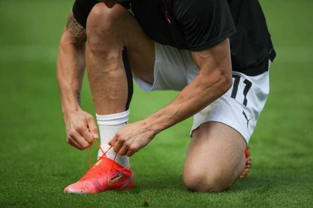 Zlatan Ibrahimovic of AC Milan adjusts his football boot, personalised with his name and the flag of Sweden during the warm up prior to the Serie A match at Giuseppe Meazza, Milan. Picture date: 3rd April 2021. Picture credit should read: Jonathan Moscrop Sportimage EDITORIAL USE ONLY. No use with unauthorised audio, video, data, fixture lists, club league logos or live services. Online in-match use limited to 120 images, no video emulation. No use in betting, games or single club league player publications. SPI-0982-0033