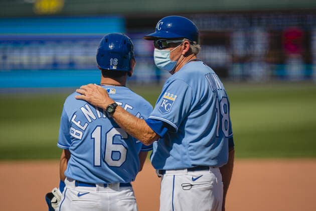Kansas City Royals first base coach Rusty Kuntz talks with left fielder Andrew Benintendi 16 during the game against the Texas Rangers at Kaufman Stadium in Kansas City, Missouri on Sunday, April 4, 2021.  KCP20210404206 KYLExRIVAS