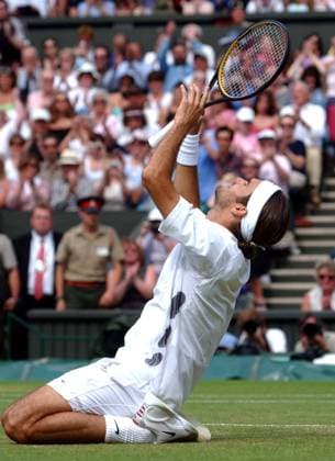 Roger Federer (Switzerland) drops to his knees in celebration of his Mens Singles Final victory over Mark Philippoussis (Australia) Wimbledon Tennis Championship, Day 13, 6 07 2003. 