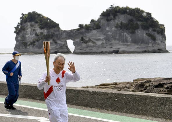 Bilder des Jahres 2021, Sport 04 April Sport Themen der Woche KW14 Sport Bilder des Tages Tokyo Olympic torch relay A Tokyo Olympic torch relay participant runs along the Pacific coast in Shirahama in Wakayama Prefecture, western Japan, on April 9, 2021. 