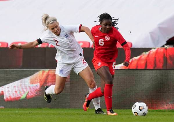 Stoke, England, 13th April 2021. Deanne Rose of Canada gets past Rachel Daly of England during the International Football Friendly match at The Bet365 Stadium, Stoke. Picture credit should read: Andrew Yates Sportimage EDITORIAL USE ONLY. No use with unauthorised audio, video, data, fixture lists, club league logos or live services. Online in-match use limited to 120 images, no video emulation. No use in betting, games or single club league player publications. SPI-0999-0013