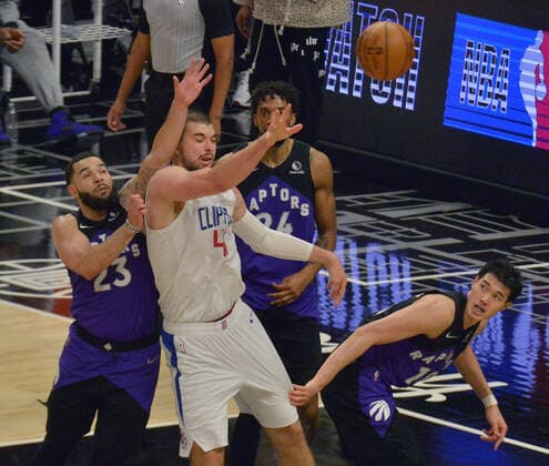 Los Angeles Clippers center Ivica Zubac (40) passes the ball under pressure from Toronto Raptors defenders during the second half at Staples Center in Los Angeles on Tuesday, May 4, 2021. The Clippers defeated the Raptors 105-100 to end a three-game losing streak.  LAP2021050403 JIMxRUYMEN