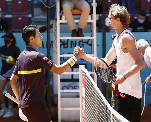 Tennis: Madrid Open Alexander Zverev (R) of Germany shakes hands over the net with Kei Nishikori of Japan after beating him in their Madrid Open second-round match on May 5, 2021, in Madrid, Spain. 