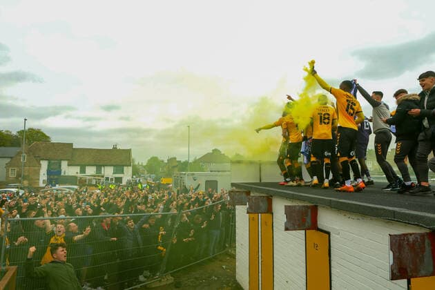8th May 2021; Abbey Stadium, Cambridge, Cambridgeshire, England; English Football League Two Football, Cambridge United versus Grimsby Town; The Cambridge Utd players celebrate from the top of their stands with fans as Cambridge Utd is promoted to EFL league 1  ActionPlus12286710 ShaunxBrooks