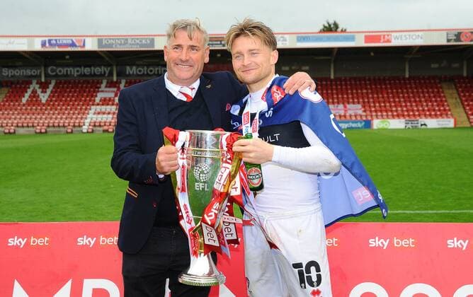 Mandatory Credit: Photo by Nizaam Jones JMP Shutterstock (11894506da) Cheltenham Town chairmen Andy Wilcox holds the trophy with Alfie May of Cheltenham Town Cheltenham Town v Harrogate Town, UK - 08 May 2021 EDITORIAL USE ONLY No use with unauthorised audio, video, data, fixture lists (outside the EU), club league logos or live services. Online in-match use limited to 45 images (+15 in extra time). No use to emulate moving images. No use in betting, games or single club league player publications services. Cheltenham Town v Harrogate Town, UK - 08 May 2021 EDITORIAL USE ONLY No use with unauthorised audio, video, data, fixture lists (outside the EU), club league logos or live services. Online in-match use limited to 45 images (+15 in extra time). No use to emulate moving images. No use in betting, games or Copyright: xNizaamxJones JMP Shutterstockx 11894506da