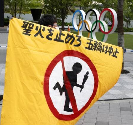 Protest against Tokyo Olympics A man holds up a banner during a protest near National Stadium in Tokyo on May 9, 2021, against holding the Tokyo Olympics amid the coronavirus pandemic, as an Olympic test event for athletics is held inside the stadium. 