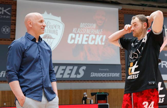 09.05.2021, Basketball, BBL 2020 2021, 34. Spieltag, s.Oliver Wuerzburg - RASTA Vechta, GER, Wuerzburg, s.Oliver Arena, Bild: v. li. Headcoach Denis Wucherer (s.Oliver Wuerzburg) und Felix Hoffmann (s.Oliver Wuerzburg) vor dem Schild Mission Klassenerhalt Copyright: HMBxMedia xHeikoxBecker