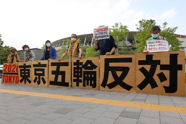 May 9, 2021, Tokyo, Japan - Anti Olympic activists hold placards to protest Tokyo 2020 Olympic Games, Olympische Spiele, Olympia, OS amid outbreak of the new coronavirus in front of the national stadium where a track and field meet, a test event of the Tokyo 2020 Olympic Games is held in Tokyo on Sunday, May 9, 2021. Noxthirdxpartyxsales  (0117374112st)