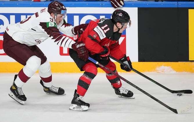 RIGA, LATVIA - MAY 21, 2021: Latvia s Oskars Batna (L) and Canada s Jaret Anderson-Dolan fight for the pick in their 2021 IIHF World Championship, WM, Weltmeisterschaft Group A Ice hockey, Eishockey match at Arena Riga. Natalia Fedosenko TASS  TS100E31