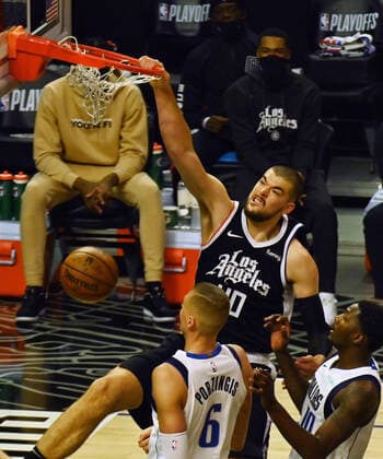 Los Angeles Clippers center Ivica Zubac dunks for two points over Dallas Mavericks forward Nicolo Melli (44) and center Kristaps Porzingis (6) during the first half of their best-of-seven playoff series opener at Staples Center in Los Angeles on Saturday, May 22, 2021. The Mavericks defeated the Clippers 113-103.  LAP2021052202 JIMxRUYMEN