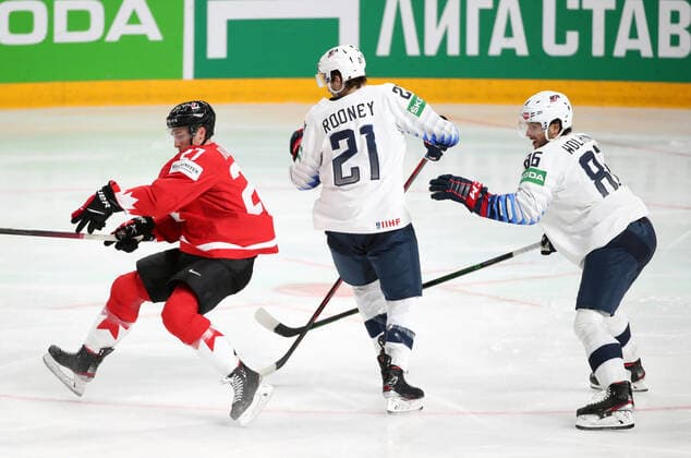 RIGA, LATVIA - MAY 23, 2021: Canada s Michael Bunting and the USA s Kevin Rooney, Christian Wolani (L-R) fight for the puck in their 2021 IIHF World Championship, WM, Weltmeisterschaft Group B Ice hockey, Eishockey match at Arena Riga. Natalia Fedosenko TASS  TS10113F