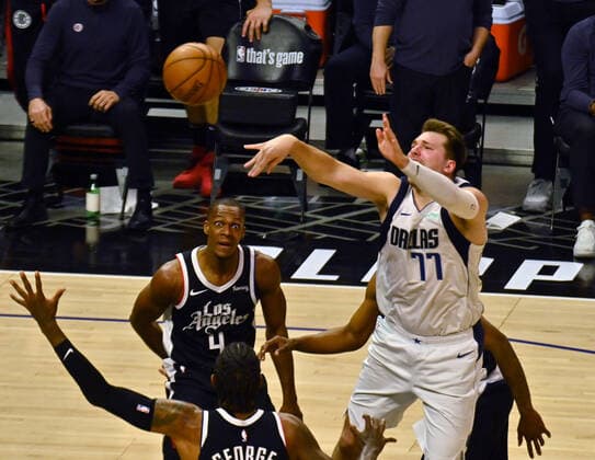 Dallas Mavericks guard Luka Doncic (77) makes a lob pass past Los Angeles Clippers forward Paul George (33) during the fourth quarter in Game 5 of their best-of-seven playoff series at Staples Center in Los Angeles on Wednesday, June 2, 2021. The Clippers lost to Dallas 105-100, their championship ambitions are hanging on for dear life trailing 3-2 in the series, with Game 6 coming on Friday in Dallas.  LAP2021060220 JIMxRUYMEN
